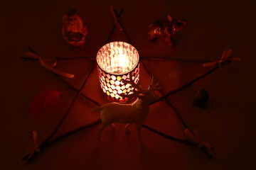 the pentagram, the fire in the candle holder and figurines for ritual magic