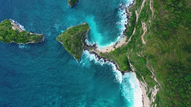 Aerial view at sea and rocks. Turquoise water background from top view. Summer seascape from air. Atuh beach, Nusa Penida, Bali, Indonesia. Travel - video