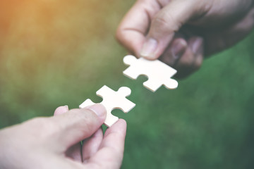 Stakeholders business team holding jigsaw puzzle as a team building and organization connection...