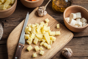 Diced potatoes on a wooden chopping board.