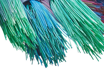 colorful plastic brooms on white