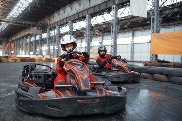 Two kart racers enters the turn, front view - obrazy, fototapety, plakaty