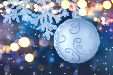 Silver Color Christmas and New Year Decoration on blurred grey background with lights. Border art design, holiday bauble. Beautiful Christmas ball closeup decorated with tinsel.