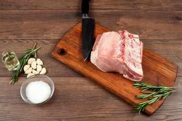 Fresh steak loin of raw meat and spices and a knife lies on a wooden background. copy space