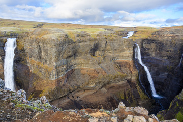 Panorama of colorful gorge with four waterfalls Haifoss, the fourth highest waterfall(122m) of the island, and Granni. The viewpoint on the sheer cliffs at the edge of canyon..