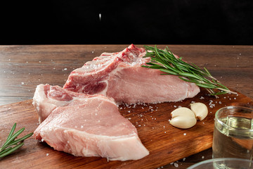 Fresh steak loin of raw meat and spices and a knife lies on a wooden background. copy space