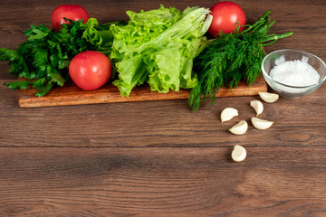 Ingredients for making salad, fresh vegetables on a wooden background.