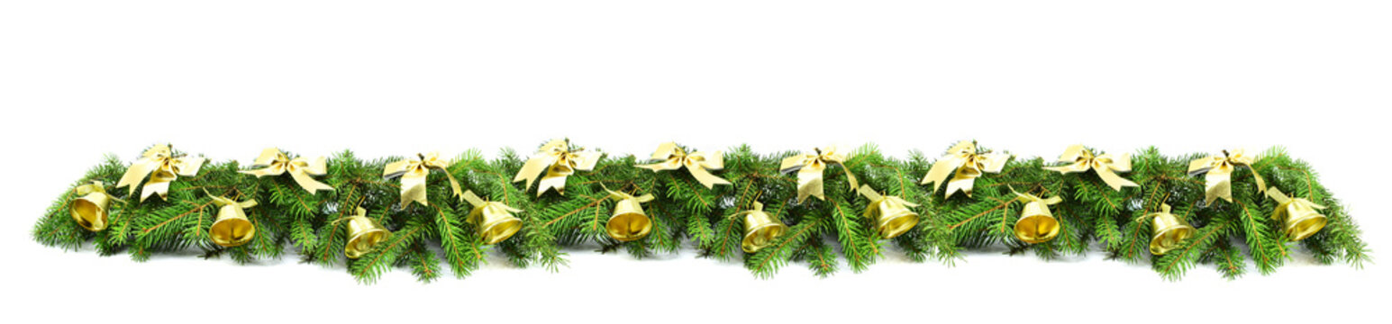 Christmas decorative wide border. Fir branches with golden bows and bells isolated on a white background.