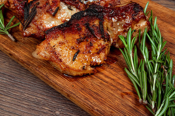 Pork steak and sprig of rosemary on a wooden cutting board. Recipe, cooking meat.