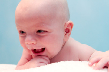Baby smiles into the camera lens.