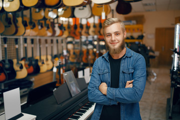 Young man poses at the showcase in music store