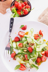 light summer detox salad with strawberries, cucumber, nuts and flax seeds