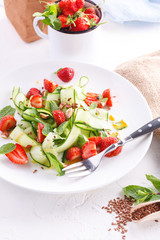 light summer detox salad with strawberries, cucumber, nuts and flax seeds