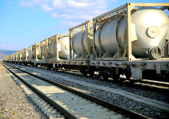 Fototapeta na wymiar white freight train wagons having oil tankers waiting on the rails