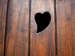 Corazón recortado en una contraventana de madera. Decoración de casas de la montaña.