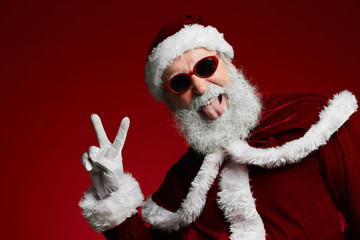 Waist up portrait of funky Santa wearing sunglasses and smiling at camera ready to enjoy Christmas...