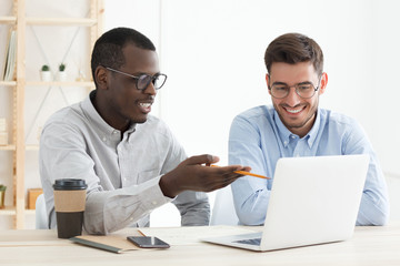 Diversity in education. African male teacher supporting his caucasian adult student while he is...