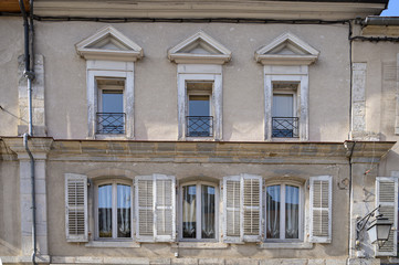 Typical facade of an old apartment above shops in the Frence town of Poligny in the Jura department in Franche-Comté.