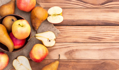 Naklejka na ściany i meble Bowl with apples and pears on wooden table. Fruit harvest. Healthy eating. Top view. Space for text.
