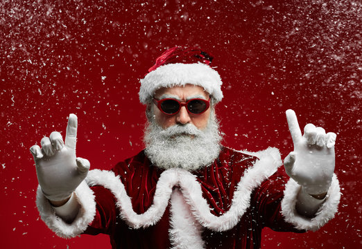 Waist up portrait of cool Santa wearing sunglasses and smiling at camera ready to enjoy Christmas party in snow