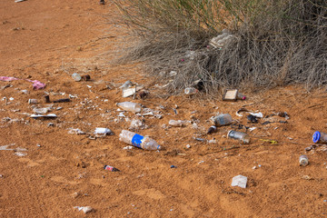 Fototapeta na wymiar Plastic pollution in the desert sand. Need for awareness of enviornmental protection, recycling, and protecting the world. Environmental concept.