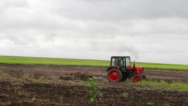 Tractor plowing field and tillage. Scenic agricultural land and farm. Agriculture.