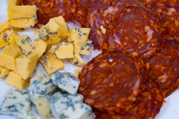 Appetizer with beer and wine. Sliced cheese with mold and salami Chorizo sausage
