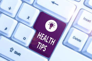 Conceptual hand writing showing Health Tips. Concept meaning advice or information given to be helpful in being healthy White pc keyboard with note paper above the white background