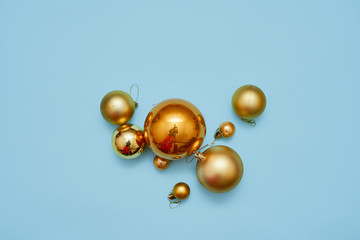 Golden metal balls on blue background. Top view. Christmas decoration. Metal molecule. Copy space