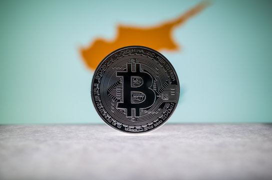 Physical silver version of Bitcoin BTC and Cyprus Flag on the background. Conceptual image for investors in cryptocurrency and Blockchain.