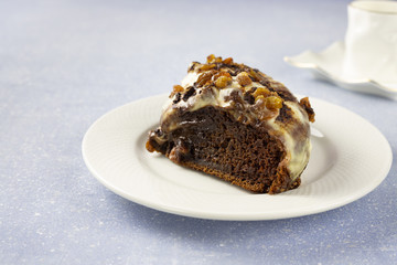 Delicious chocolate cake with raisins and cream. Piece of Chocolate Cake on a Plate. Sweet food. Sweet dessert. Light bakcground. Close up.