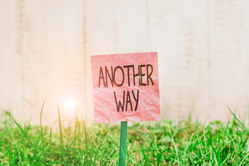 Conceptual hand writing showing Another Way. Concept meaning way or another to refer to two possible decisions or conclusions Plain paper attached to stick and placed in the grassy land