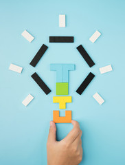 Hand push last piece jigsaw light bulb to finish success planning idea concept solve puzzle...