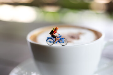 Miniature people : Coffee cup with cycling, image use for charge your energy in the morning