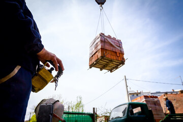 Worker is holding remote, wireless, control for overhead crane © Roman_23203