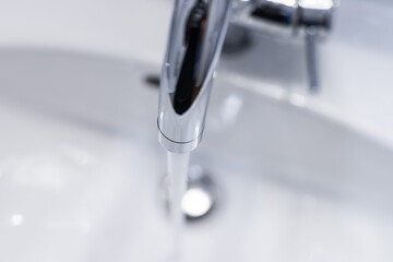 Saving water: Close up of spigot with clear, flowing water