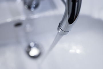 Saving water: Close up of spigot with clear, flowing water