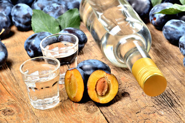 Shots of Slivovice, typical Eastern Europe alcohol plum brandy and bottle at background.