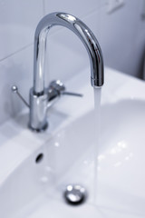 Saving water: Close up of spigot with clear, flowing water