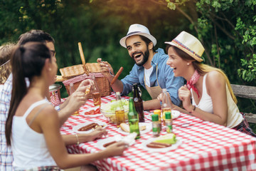 Group of friends enjoying a lunch time together in the nature.