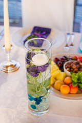 White eustoma flower in a glass vase with water on a festive table