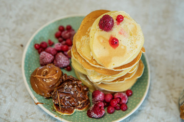 Little curly boy eating sweet pancakes