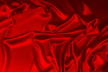 Red silk or satin luxury fabric texture can use as abstract background. Top view.