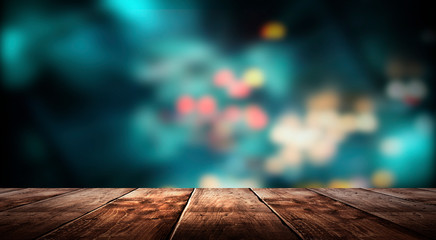 Wooden table, blurred bokeh background background. Neon light, night view, close-up. The general...