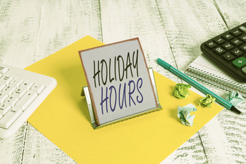 Fototapeta premium Word writing text Holiday Hours. Business photo showcasing employee receives twice their normal pay for all hours Notepaper stand on buffer wire in between computer keyboard and math sheets