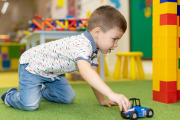 Children play with educational toys. Children sit on the carpet in the playroom at home or in the kindergarten.boy with toy cars