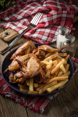 Baked chicken wings with french fries.