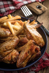 Baked chicken wings with french fries.