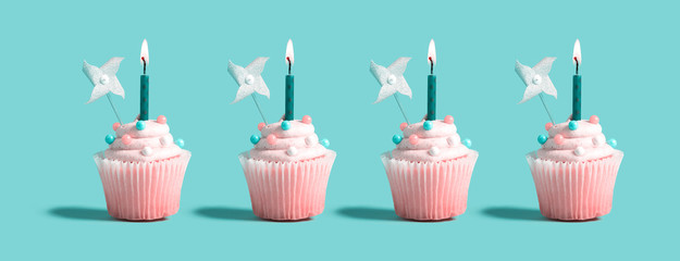Tasty celebratory cupcakes with decorative lit candles