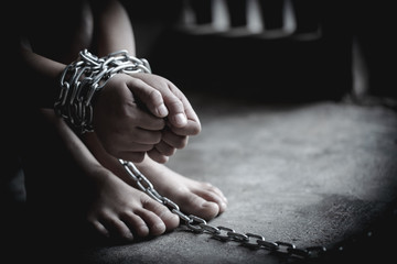 Hopeless man hands tied together with chain, Victims of human trafficking